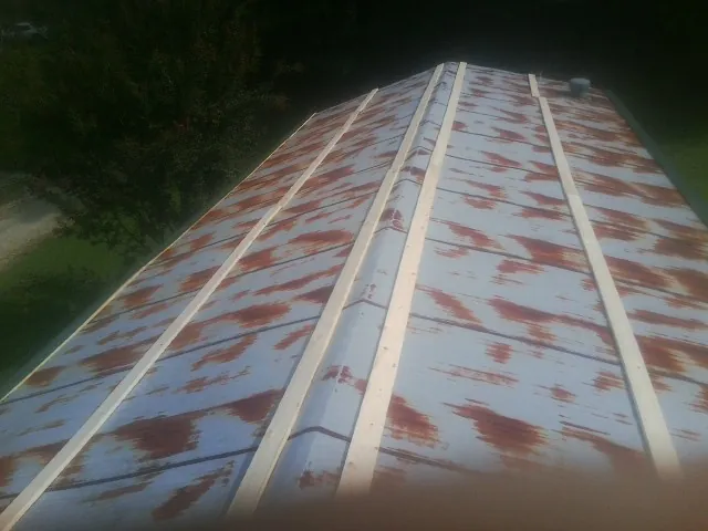 Rusted metal roof panels with new wood purlins before replacement — Storm Damage Roof Repair in Carville by Roofing Brothers