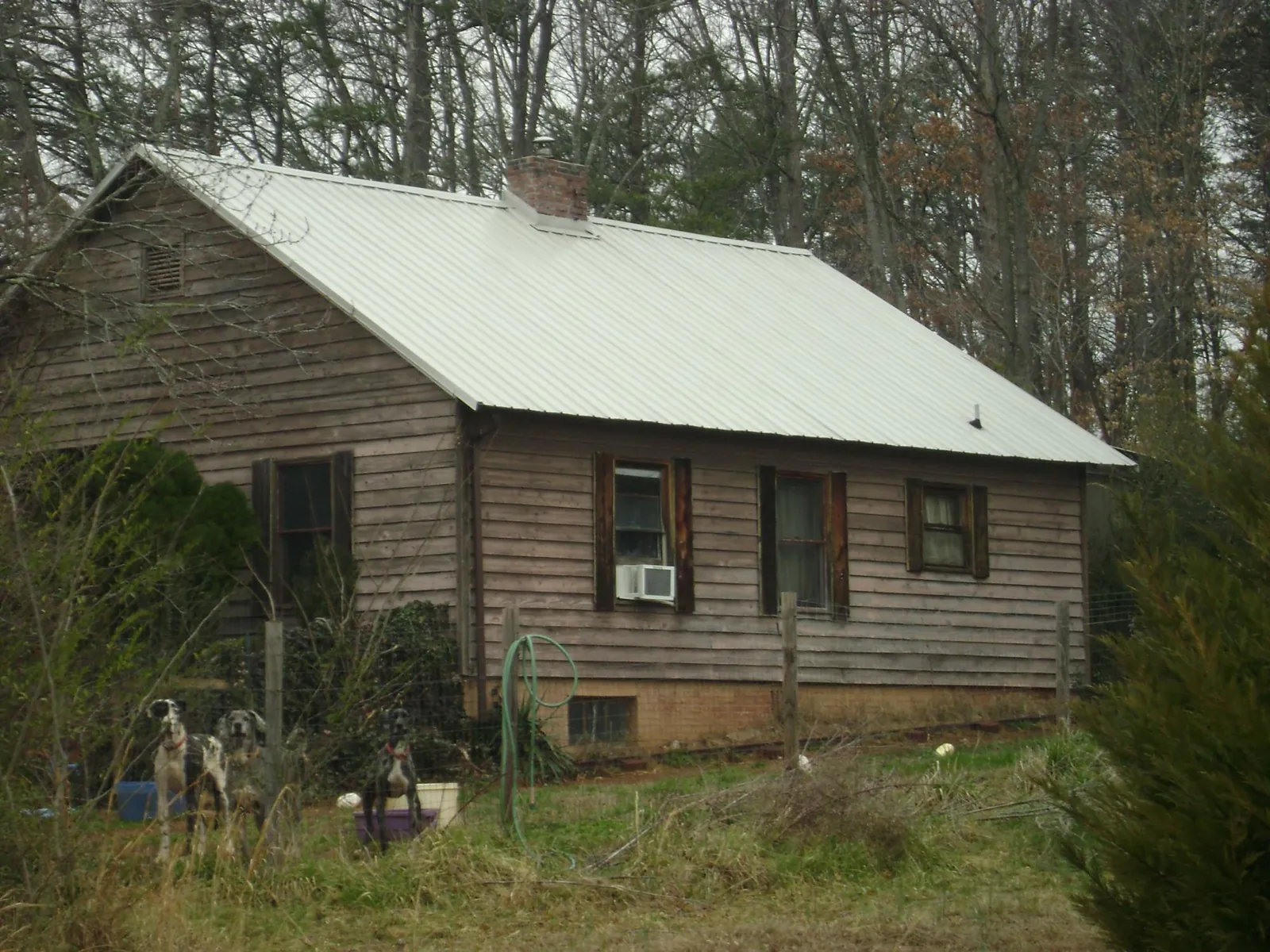 White metal roof on an old wood sided farmhouse, from a Metal Roof Installation job in Carville